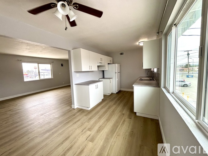 A kitchen with white cabinets and a ceiling fan.