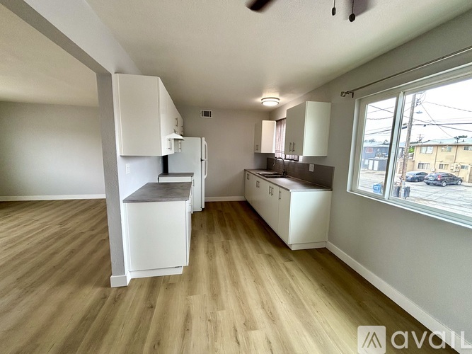 A kitchen with white cabinets and a wooden floor.