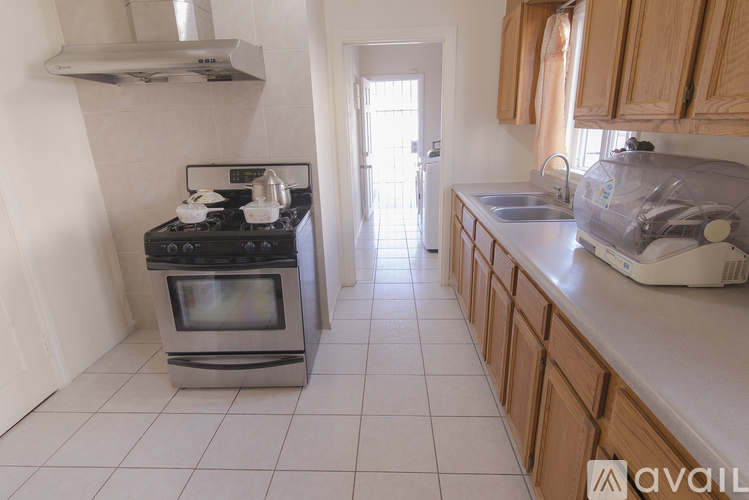 A kitchen with a stove, sink, and cabinets.