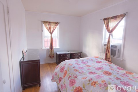 A bedroom with a large bed and a wooden cabinet.