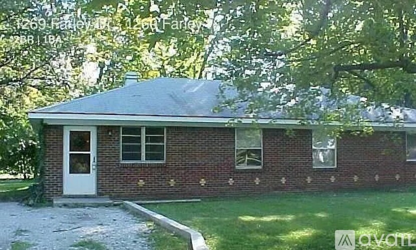 A small house with a white door and windows is surrounded by trees.