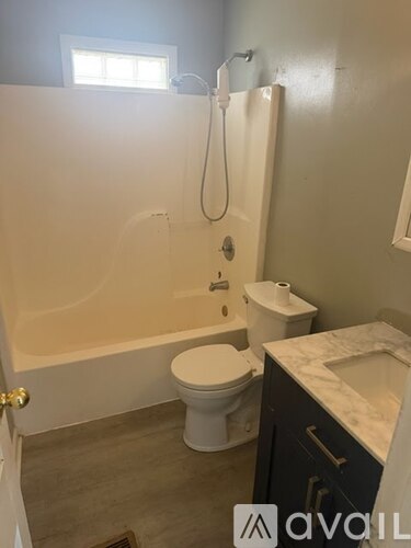 A bathroom with a toilet, sink, and bathtub.