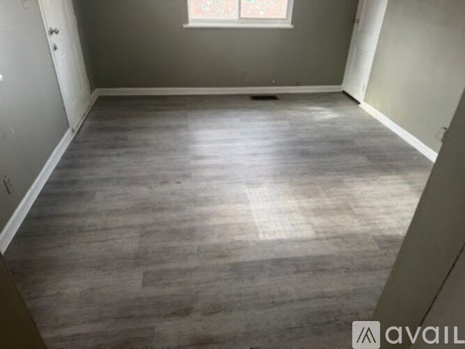 A room with wooden flooring and a window.