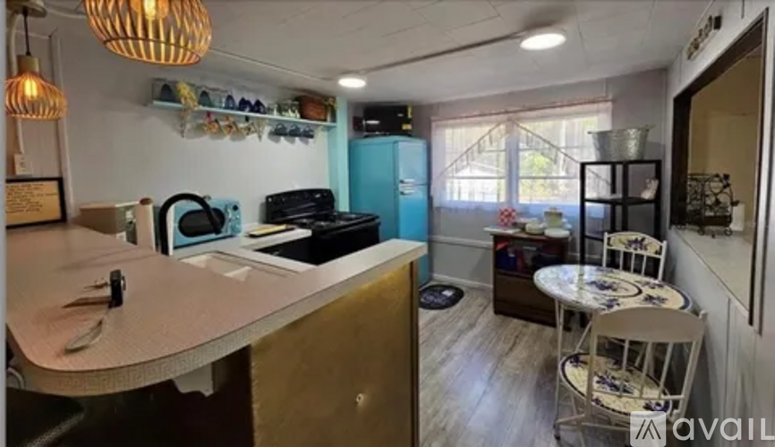 A kitchen with a table and chairs in the foreground and a blue refrigerator in the background.