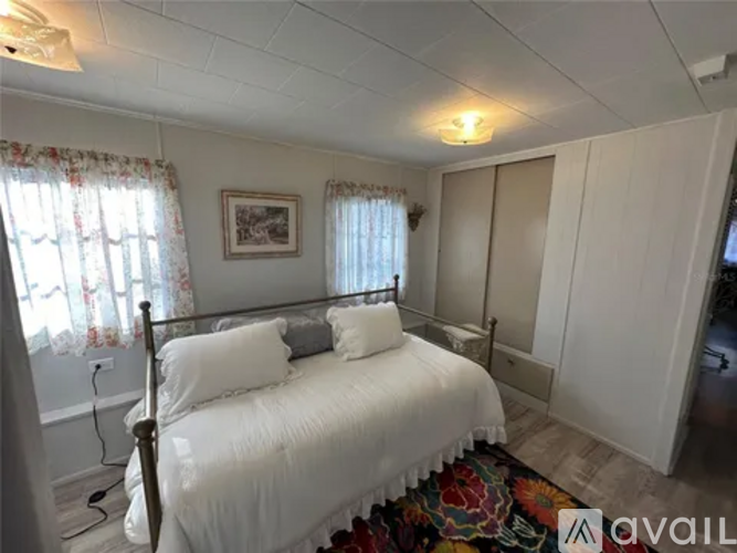 A bedroom with a four poster bed and a window with curtains.