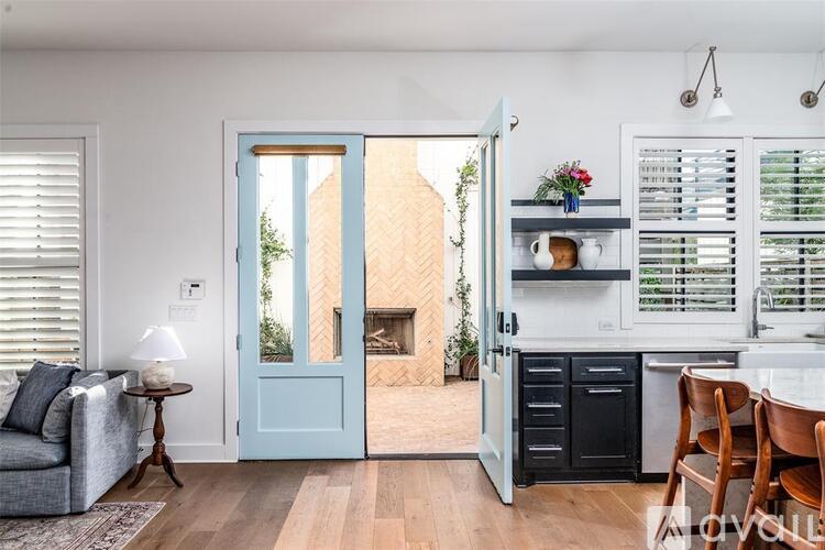 A modern kitchen with a blue door leading to a balcony.