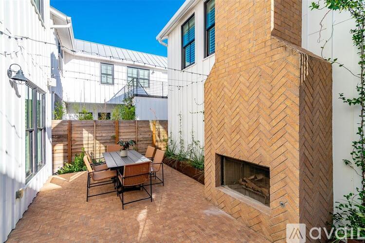 A patio with a table and chairs and a fireplace.