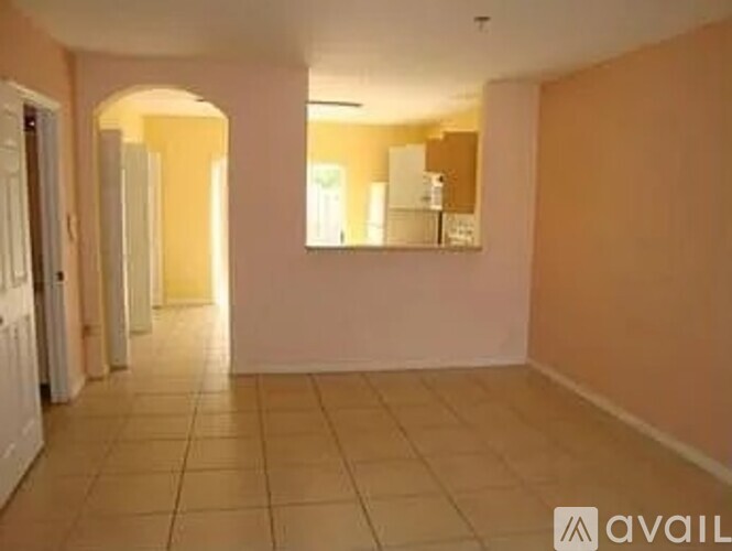 A hallway with a mirror and tiled floor.