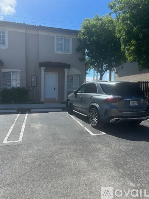 A car is parked in a parking lot in front of a building.