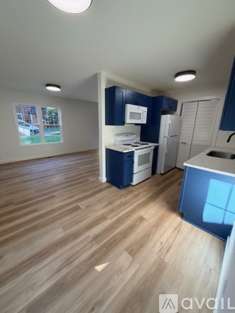 A kitchen with blue cabinets and a wooden floor.