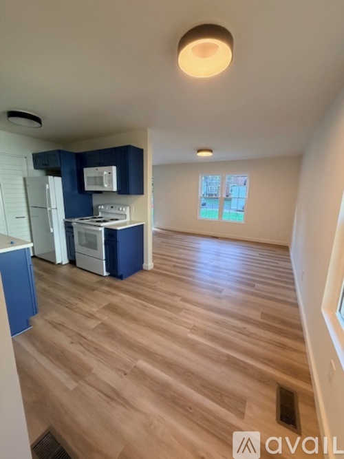 A kitchen with blue cabinets and a white fridge.