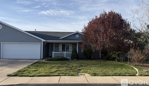 A house with a grey roof and a white garage door.