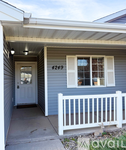 A house numbered 4249 with a white fence in front.