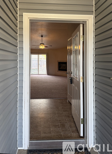 A hallway with a light hanging from the ceiling and a door on the right.