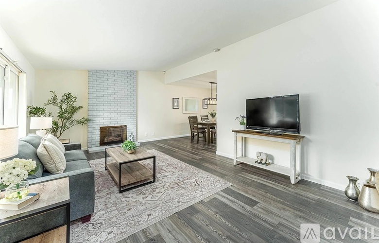 A living room with a grey sofa, a coffee table, a television, and a fireplace.