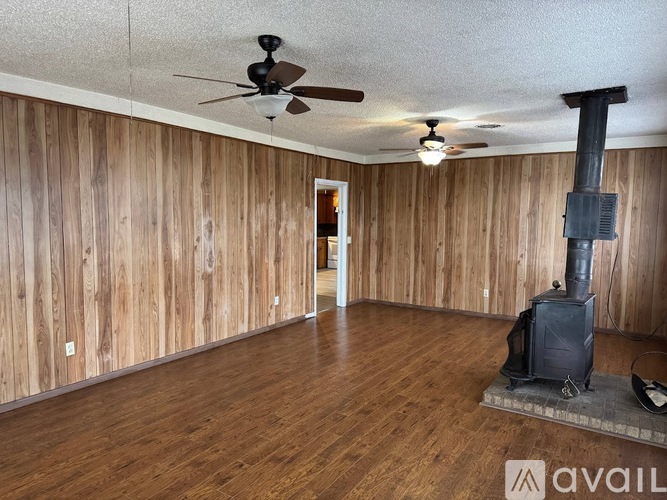 A room with wood paneling and a wood burning stove.