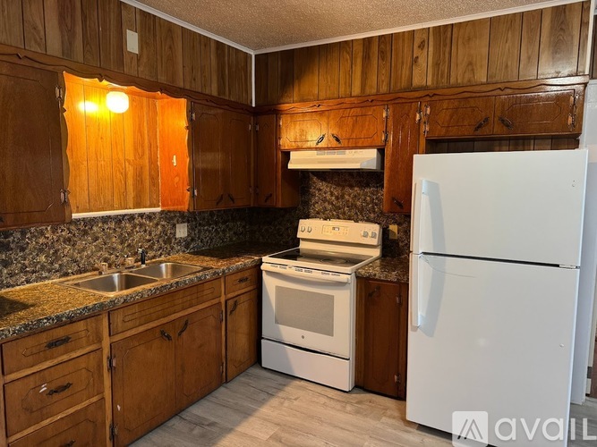 A kitchen with wooden cabinets and a white refrigerator.
