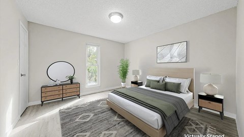 A bedroom with a large bed, a dresser, and a mirror.