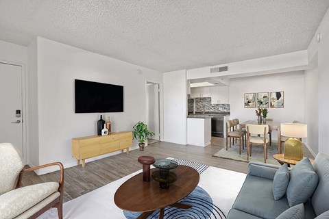 A living room with a white couch and a wooden coffee table.