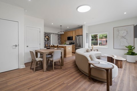 A modern living room with a dining table and chairs.