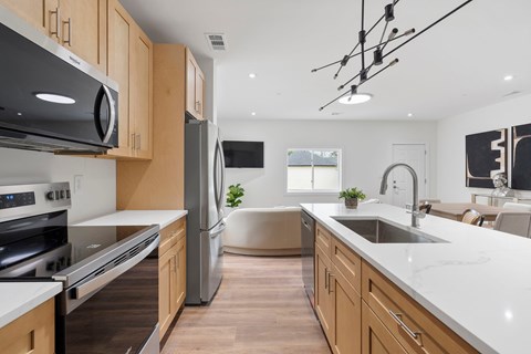 A modern kitchen with wooden cabinets and stainless steel appliances.