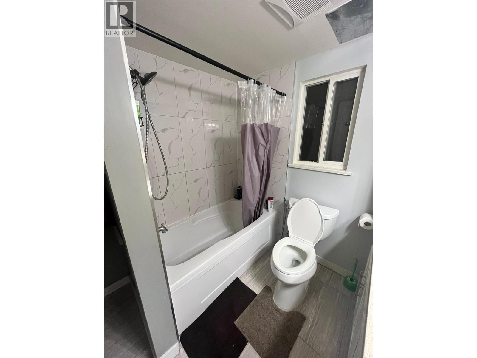 A bathroom with a toilet, sink and window.