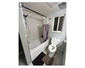 A bathroom with a toilet, sink and window.