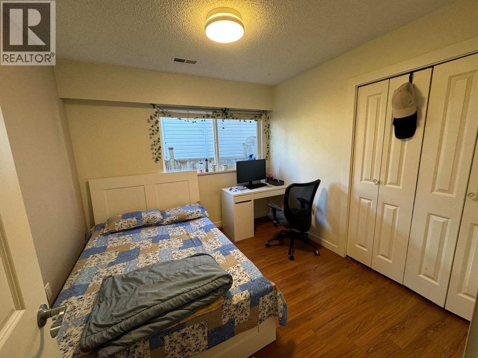 A bedroom with a bed, desk, and chair.