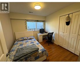A bedroom with a bed, desk, and chair.