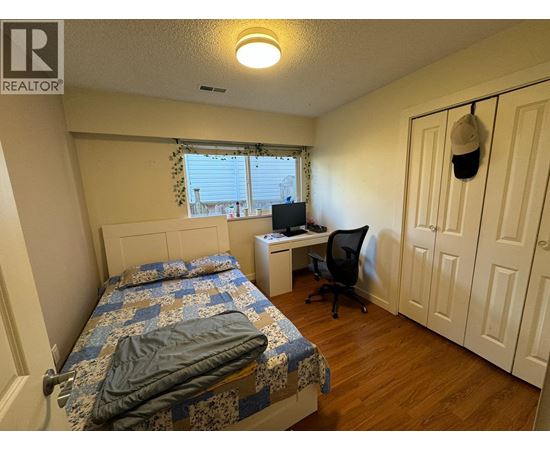 A bedroom with a bed, desk, and chair.