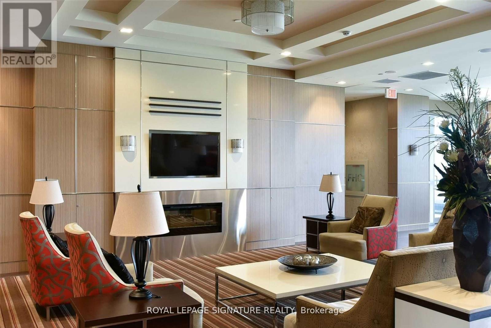 A living room with a television, chairs, and a coffee table.