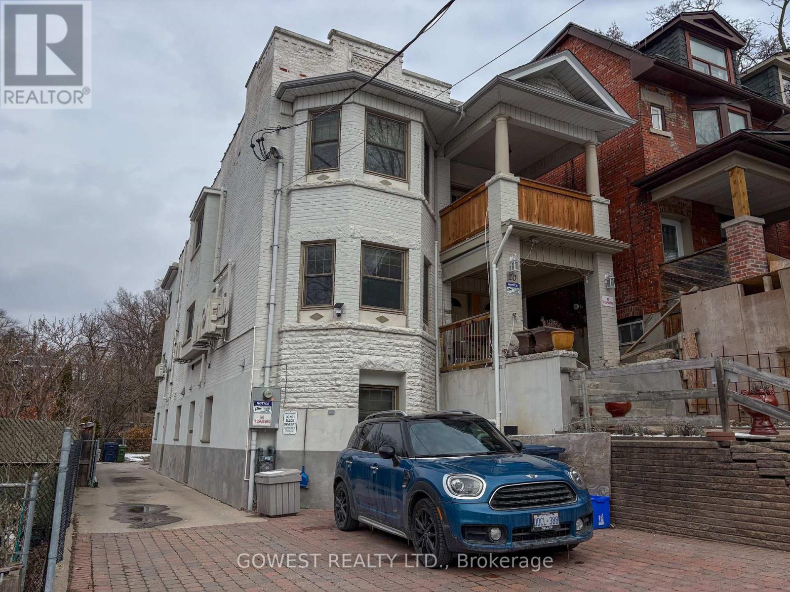 A white two-story house with a balcony on the second floor.