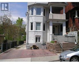 A white two-story house with a balcony on the second floor.