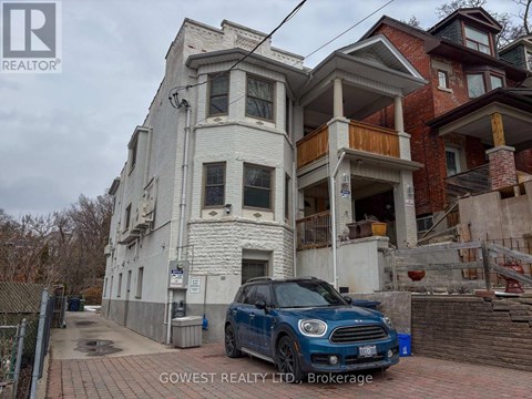 A white two-story house with a balcony on the second floor.