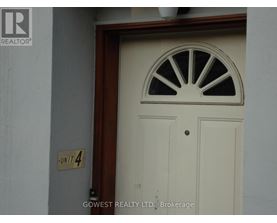 A white door with a window above it and a sign on the wall that says "Unit 4".