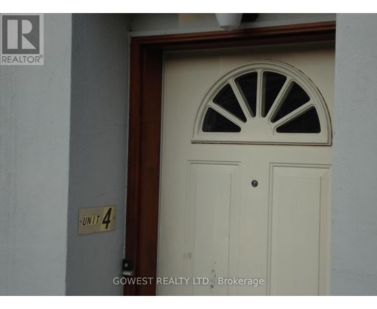 A white door with a window above it and a sign on the wall that says "Unit 4".
