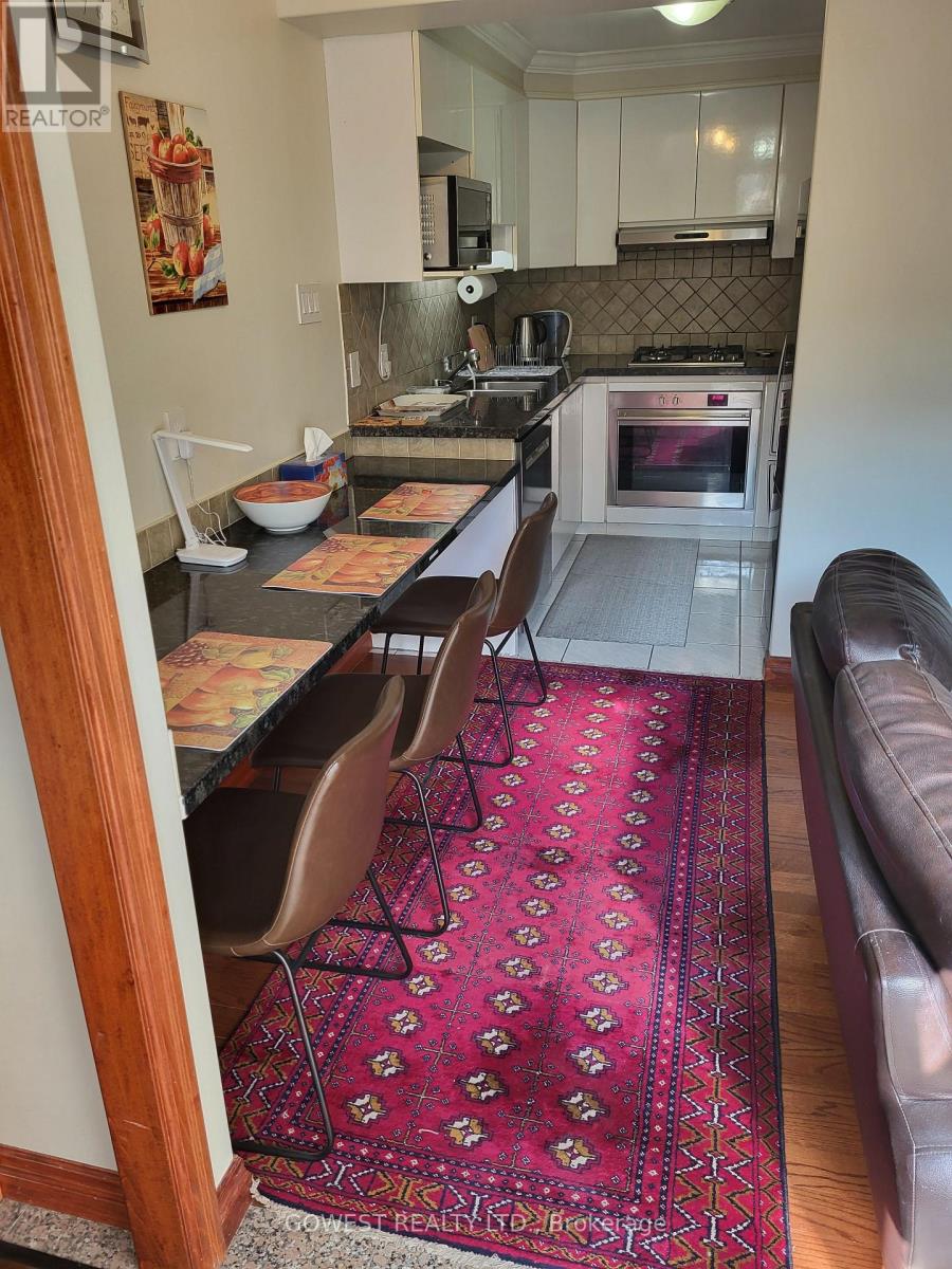 A kitchen with a red rug on the floor.