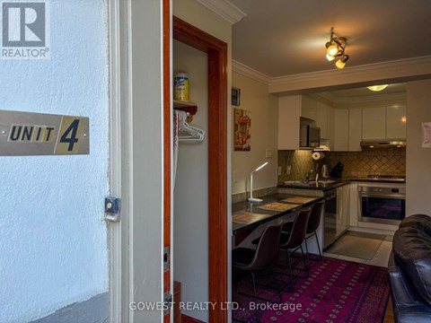 A kitchen with a red rug on the floor.