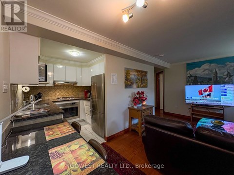 A living room with a brown leather couch and a flat screen TV mounted on the wall.
