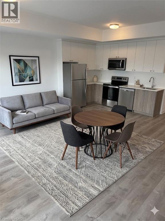 A modern kitchen with a grey sofa and a round wooden table.