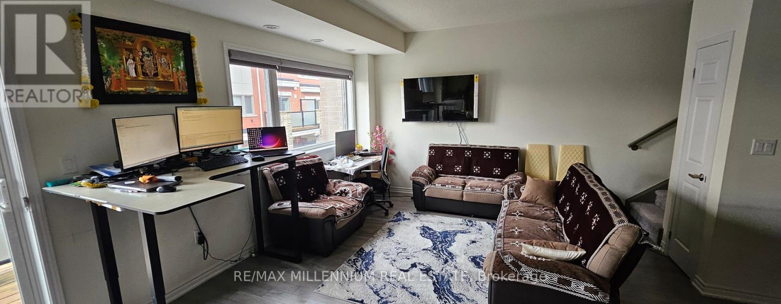 A living room with a couch, a chair, and a television.