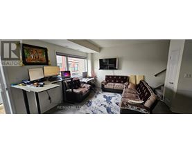 A living room with a couch, a chair, and a television.