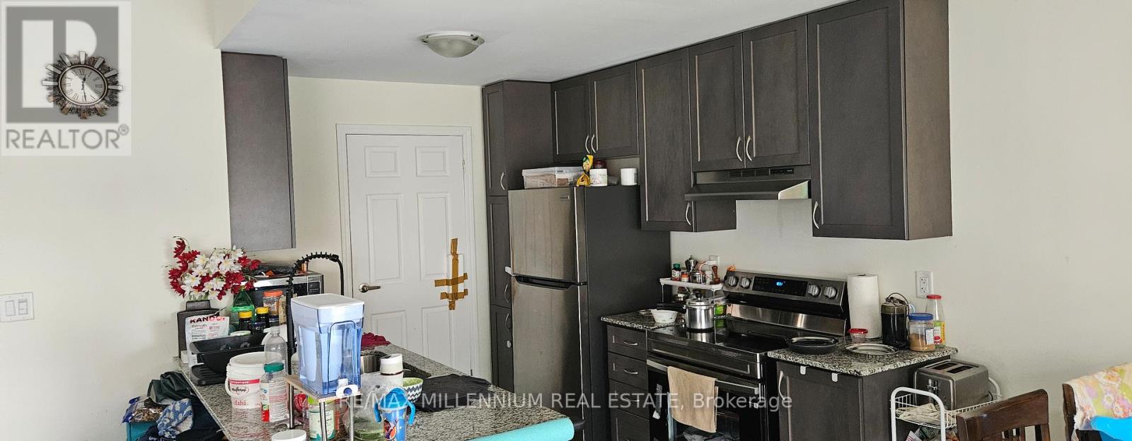 A kitchen with a refrigerator, oven, and microwave.