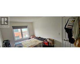 A bedroom with a bed, a window, and a door.