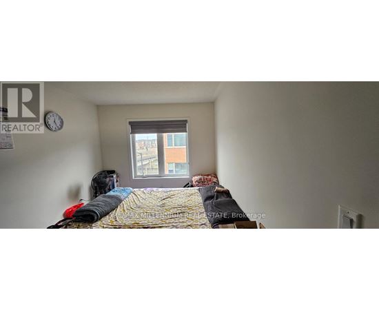 A bedroom with a bed, a window, and a clock on the wall.