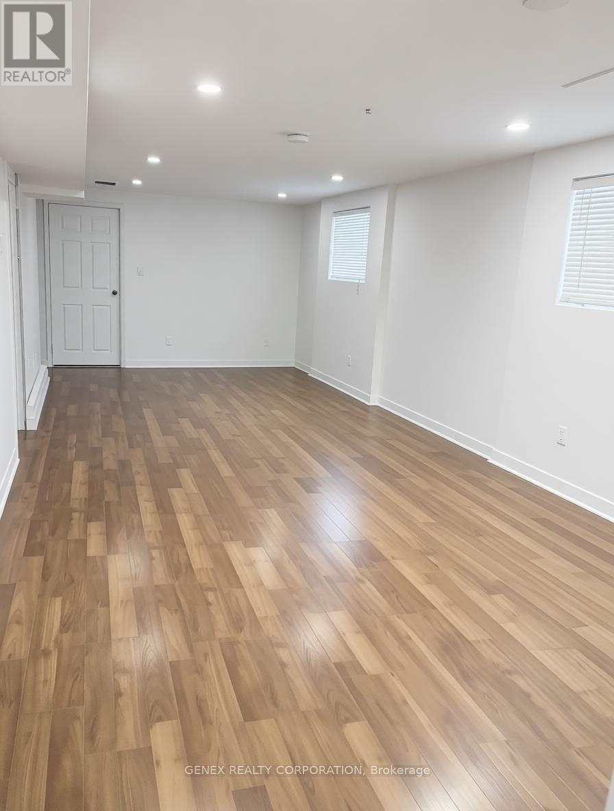 A room with wooden flooring and white walls.