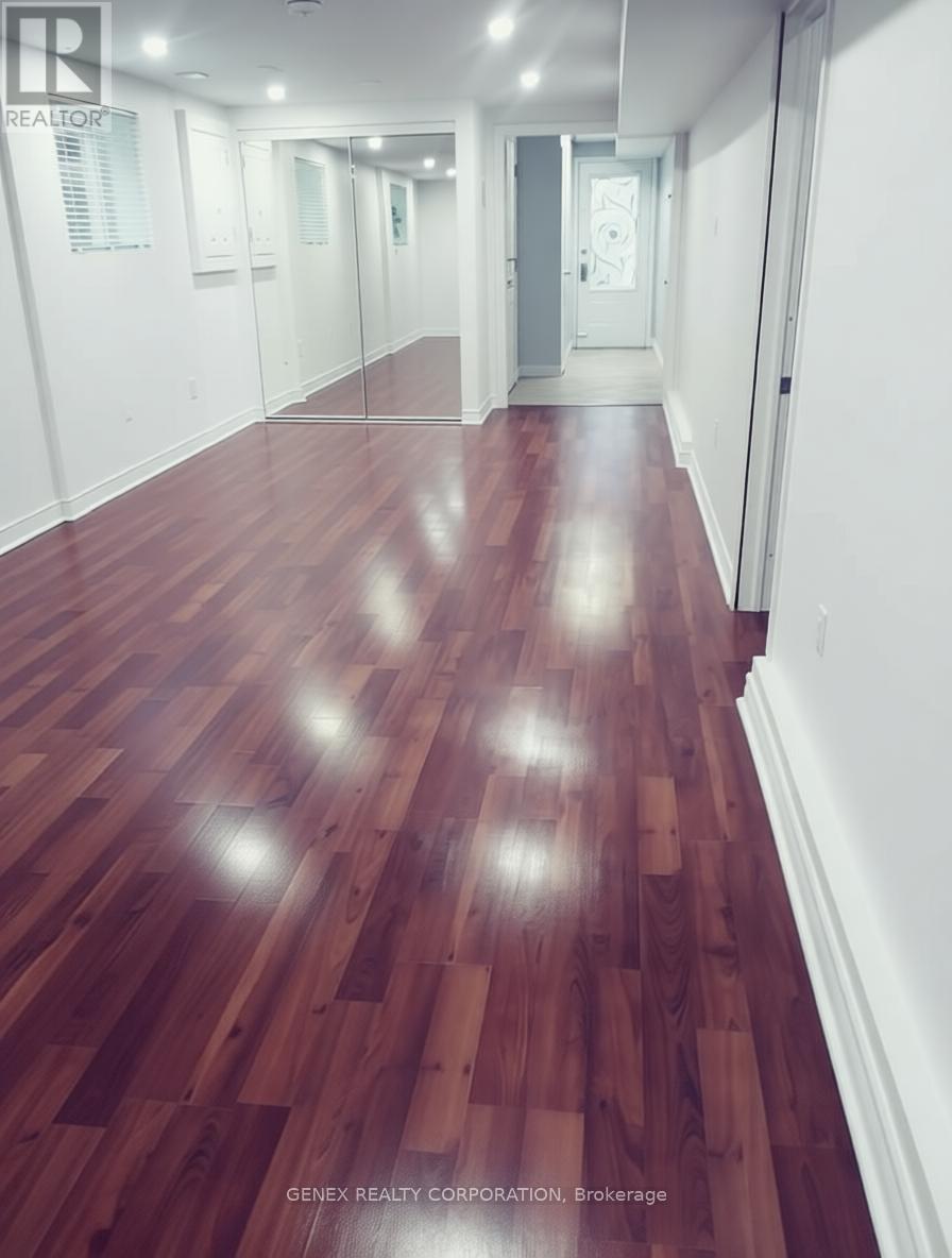 A hallway with wooden floors and white walls.