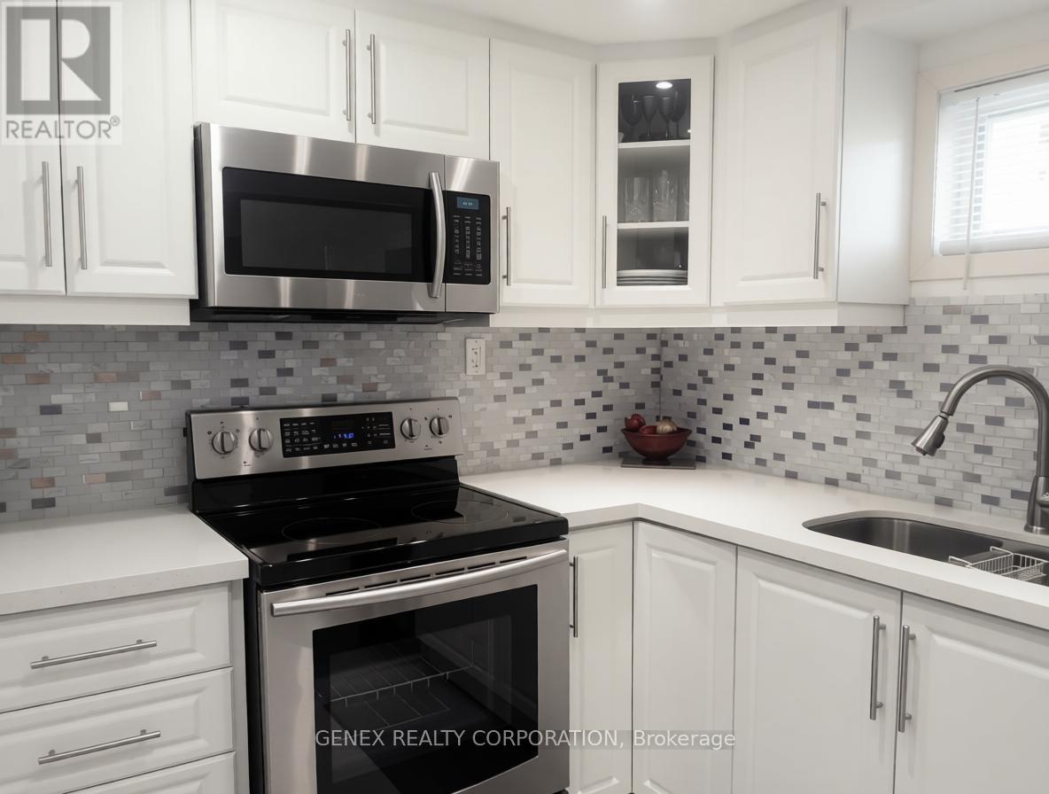 A kitchen with white cabinets and a black stove top oven.