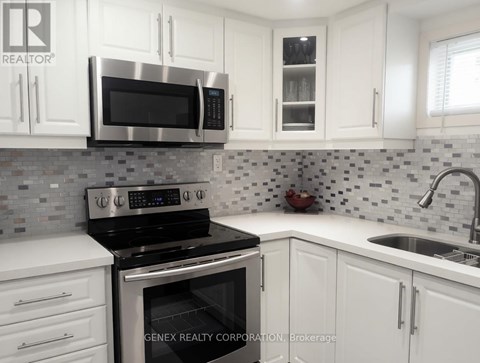 A kitchen with white cabinets and a black stove top oven.