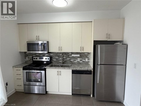 A kitchen with white cabinets and stainless steel appliances.